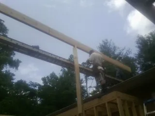 Carpenter setting a ridge beam over a new addition frame — Ice Dam Removal by Roofing Brothers in Medicine Lodge